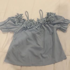 Light blue flower appliqué , cold shoulder top. Brand new.